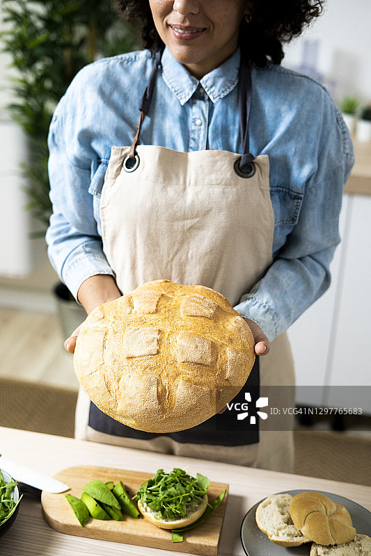 年轻女子的腹部，手里拿着刚烤好的面包图片素材