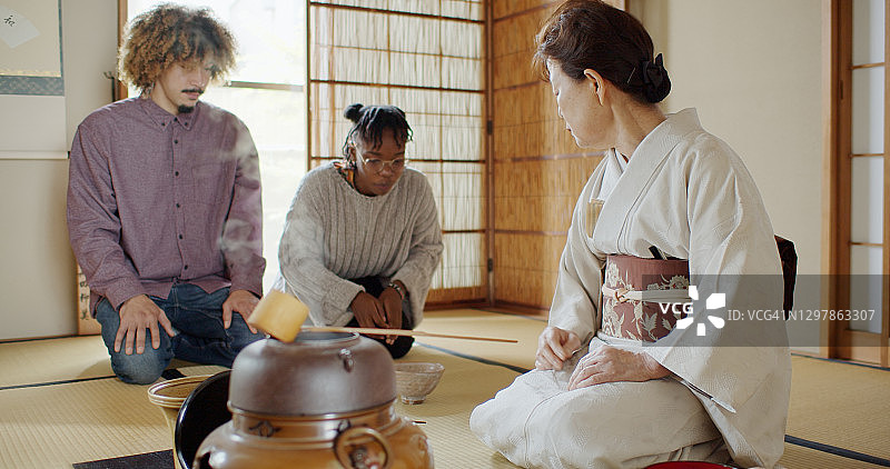非裔美国客人在日本茶道上看茶杯图片素材