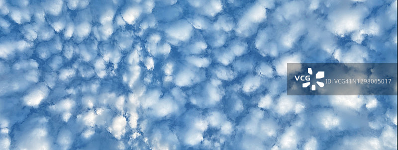 在晴朗的日子里，蓝天上的奇怪的云像油画的颜色，自然风景。查找。长、宽屏幕图片素材