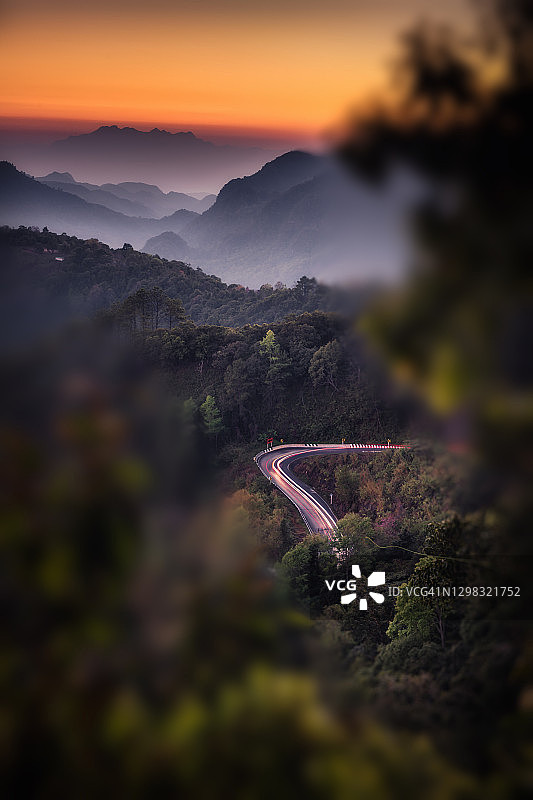 自然景观的风景与车辆轻步道在日落的山脉。图片素材
