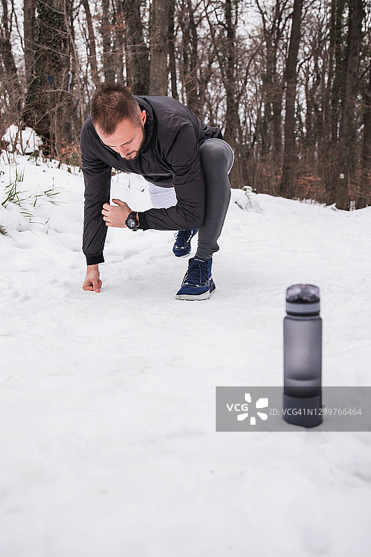 一个人在雪地上运动，身边有一瓶水图片素材