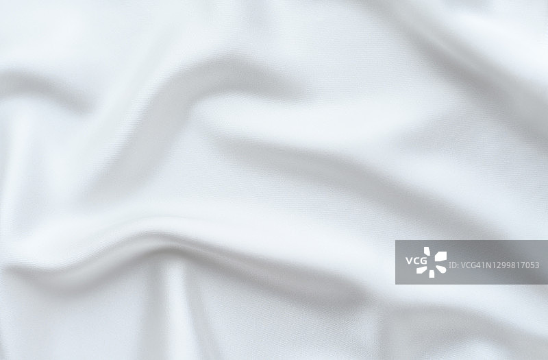 背景是由精致流畅的白色丝绸轻折叠而成。图片素材