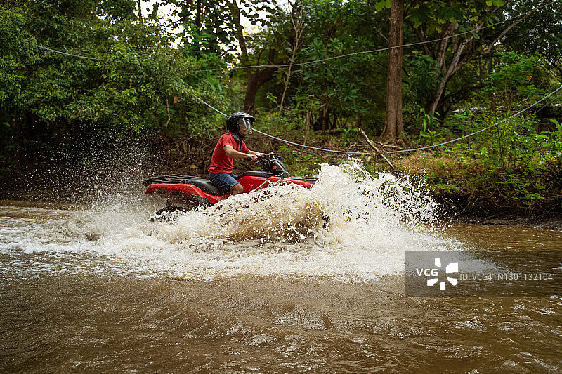 十几岁的男孩开着4x4穿越哥斯达黎加的一条河图片素材