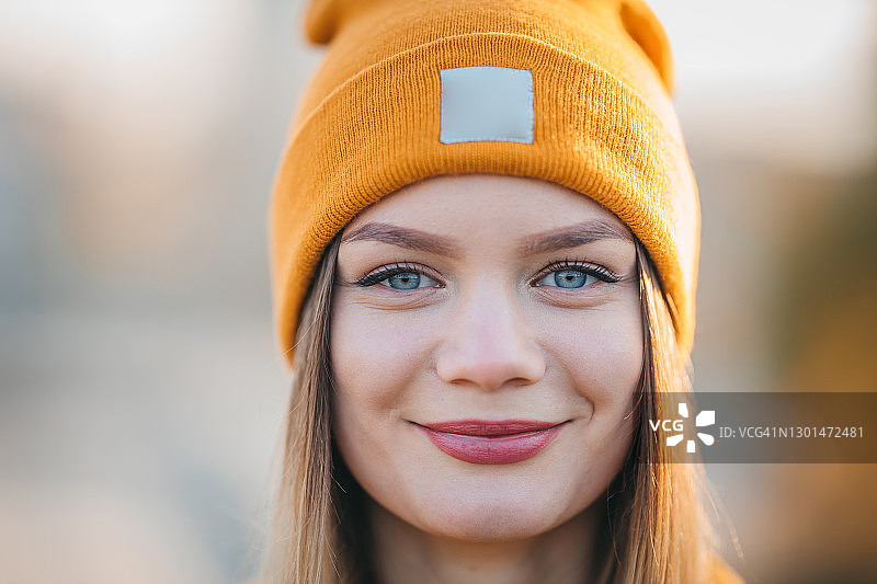 一个戴着橙色帽子的漂亮女孩的肖像图片素材