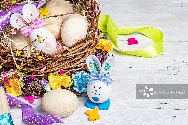 手工制作的传统复活节符号概念。可爱的兔子从鸡蛋在篮子里，柳条花环与鲜花，节日装饰图片素材
