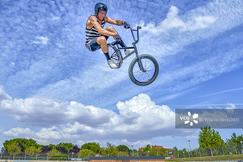 无忧无虑的人骑着自行车在自行车公园的蓝天上跳跃图片素材