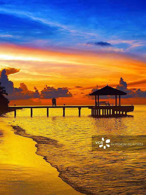 一对夫妇在码头上看日落，马尔代夫，印度洋，亚洲图片素材