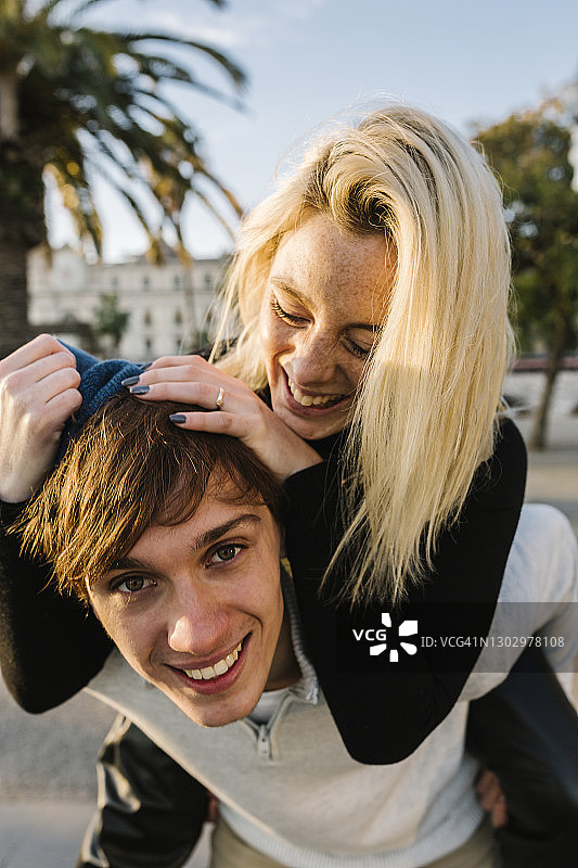 年轻男子让女朋友骑在他背上图片素材