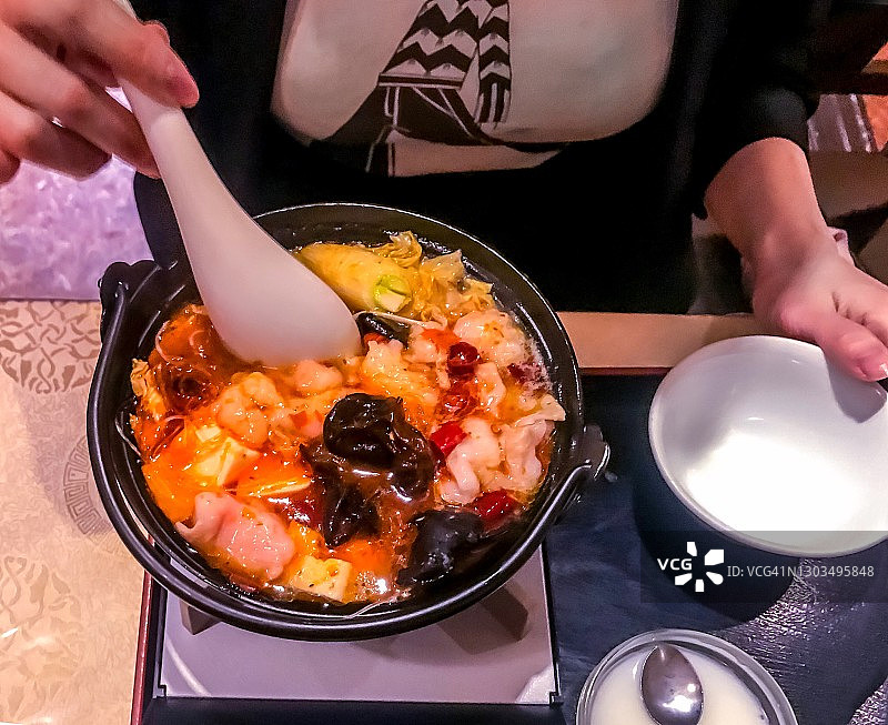 东京，一名女子在中餐馆吃迷你火锅午餐图片素材