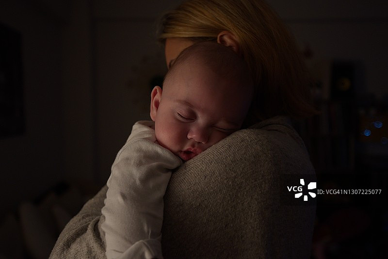 母亲抱着熟睡的男婴图片素材