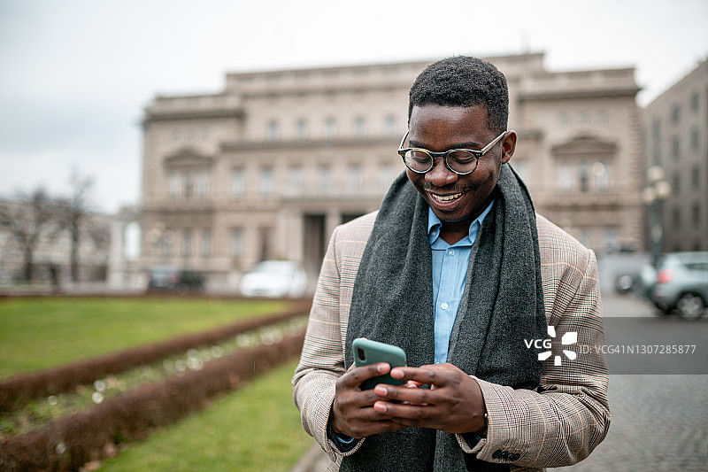 快乐的年轻非洲裔美国商人使用智能手机图片素材
