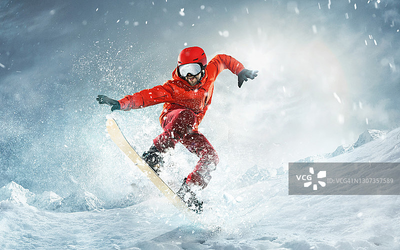 以深蓝色的天空为背景，在空中滑雪。滑雪运动员在雪地上飞行的动作和动作图片素材