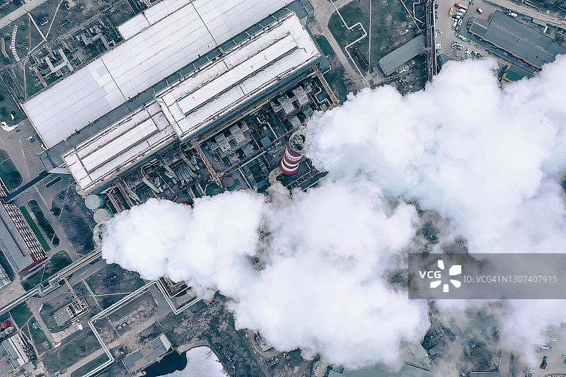 有白烟的管道。城市燃气锅炉房的管道，白色的烟雾映衬着天空。无人机俯视图。图片素材