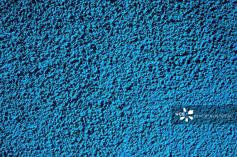 凹凸不平的建筑外墙粉刷成明亮的浅蓝色图片素材