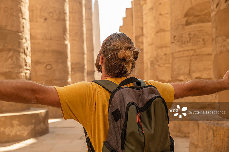 一名男子在埃及旅行，在神庙里张开双臂图片素材