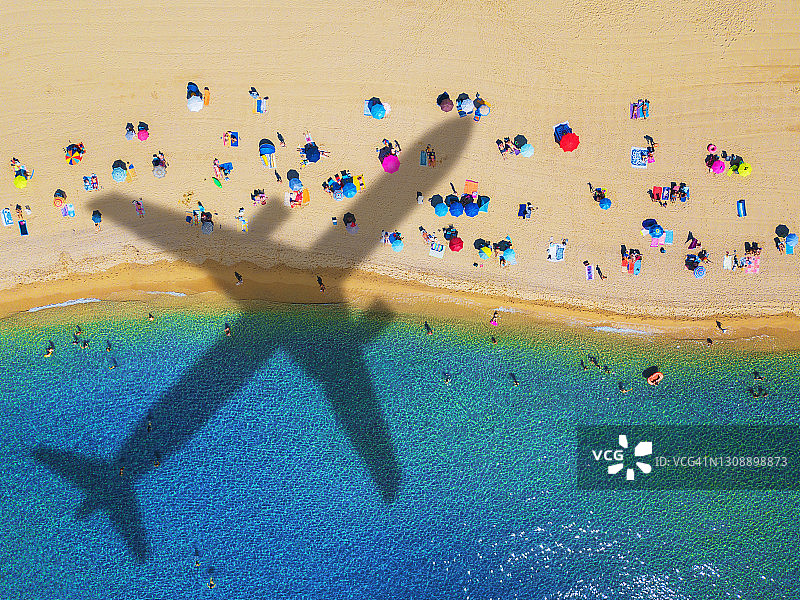 海滩上的波浪和商业飞机在美丽的热带海滩上空飞行的影子图片素材
