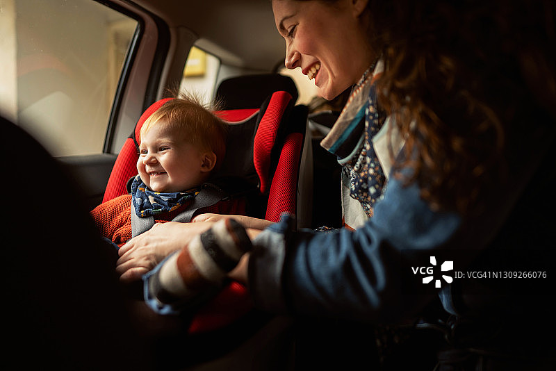 快乐的妈妈和她的宝贝儿子在后座上开车图片素材