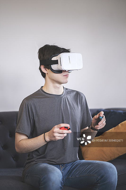 一个年轻人用虚拟现实设备玩游戏图片素材