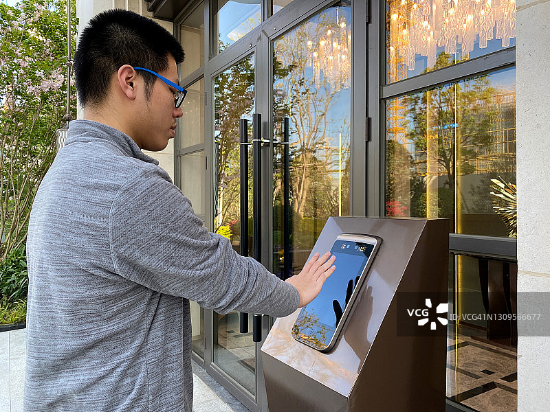 一名亚洲男子通过掌纹进行智能识别进入大楼图片素材