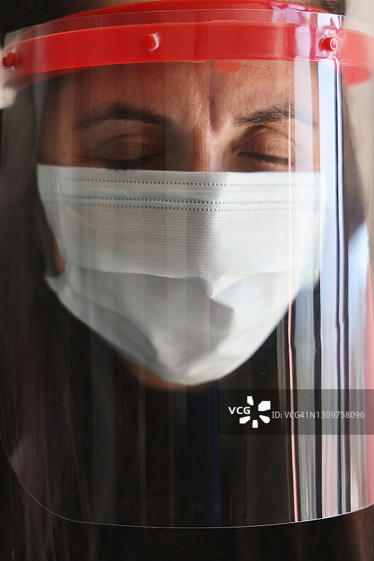 妇女佩戴双重防护口罩，预防COVID-19图片素材