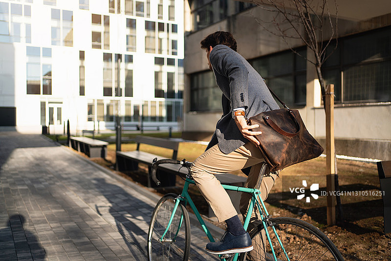 年轻的商人骑自行车去上班图片素材