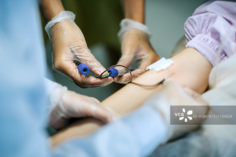 一名亚裔华裔女护士在诊所为一名中国女性患者的手臂静脉采血图片素材