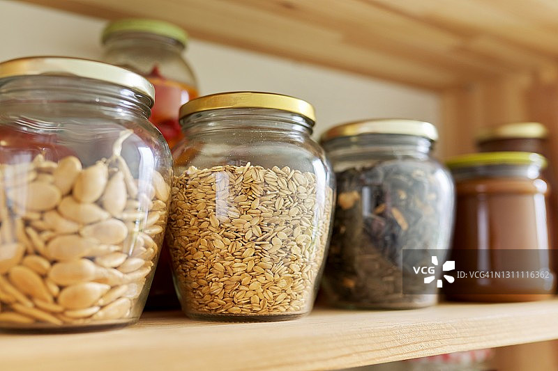 厨房的食品储藏室，木架子上放着盛有食物的罐子和容器，食物存放处。图片素材