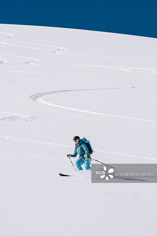 女滑雪者在冰雪覆盖的冰川上做大转弯图片素材