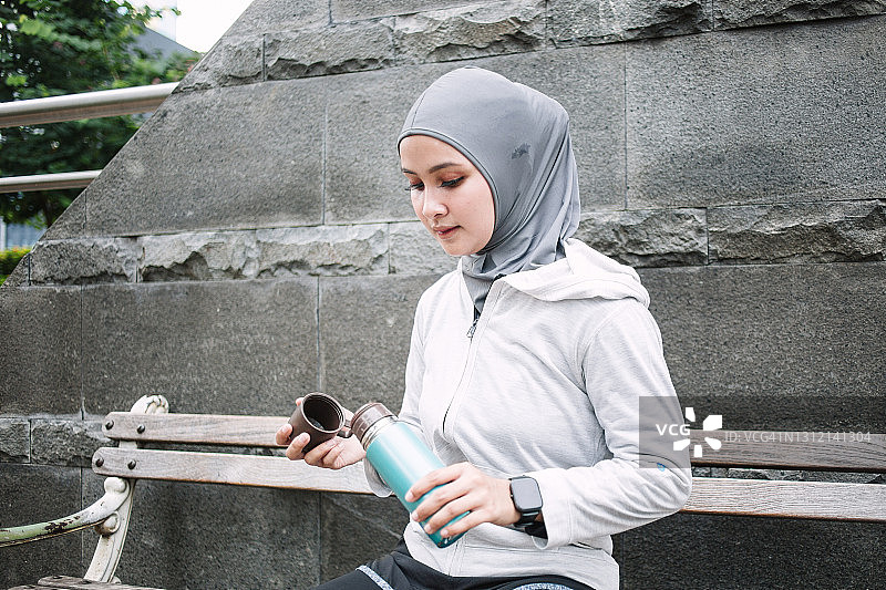 印度尼西亚女运动员在锻炼休息期间喝酒图片素材