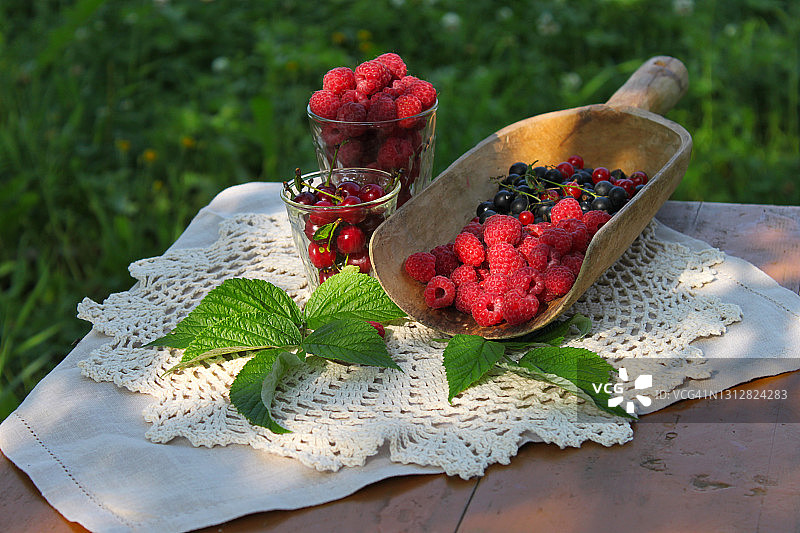 浆果，红黑加仑子，覆盆子，樱桃，亚麻餐巾，木桌，草皮背景图片素材