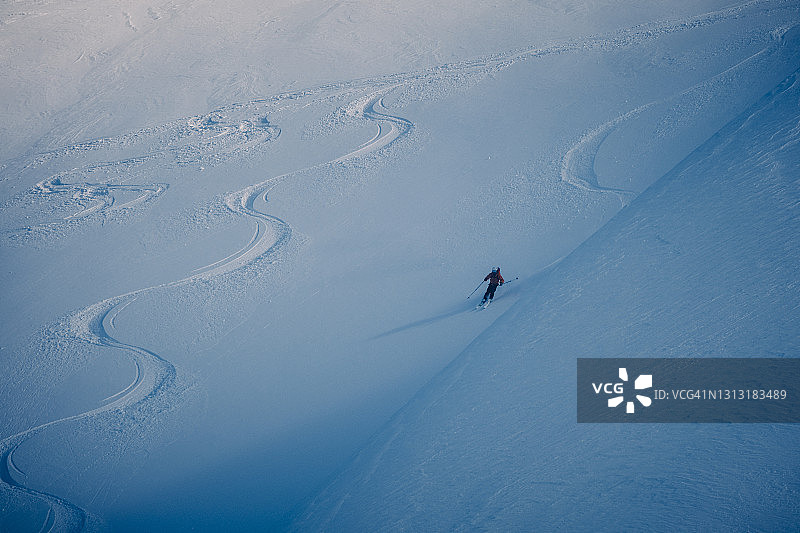 滑雪者从黑暗阴沉的雪坡上滑下来图片素材