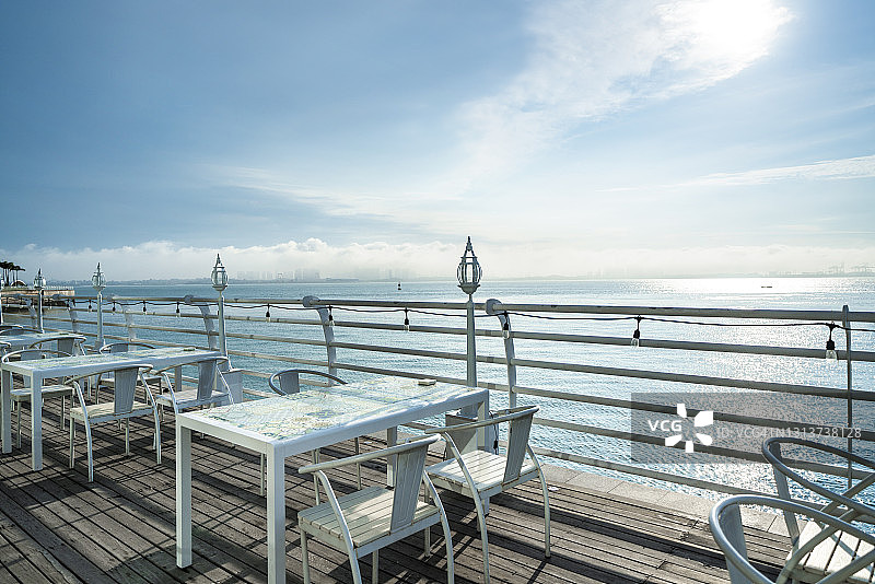 餐厅阳台上的空桌子，可以俯瞰海滩图片素材
