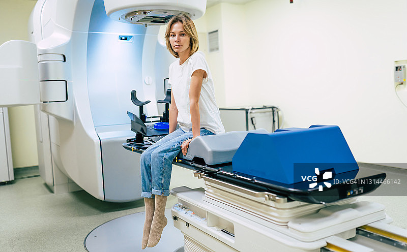 癌症治疗在现代医疗私人诊所或医院用直线加速器。在这名妇女接受癌症放射治疗时，专业的医生团队正在工作图片素材
