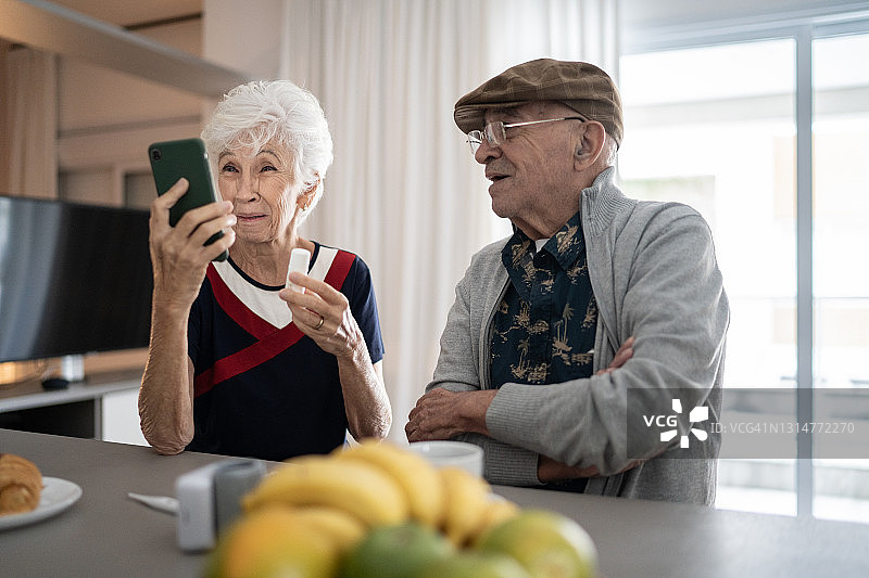 一对老年夫妇在家里用手机进行视频通话图片素材