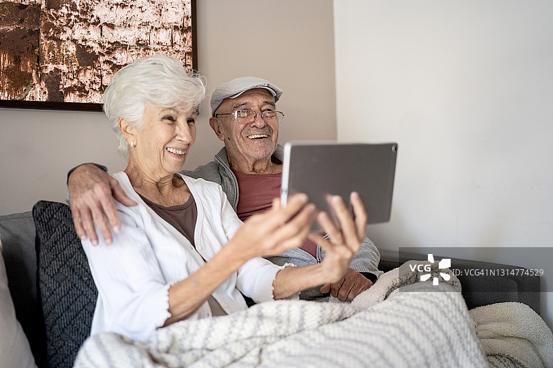 一对老年夫妇在家里用平板电脑进行视频通话图片素材