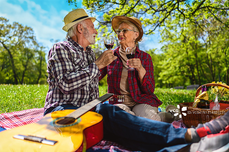 老夫妇喝着酒，享受着野餐。图片素材