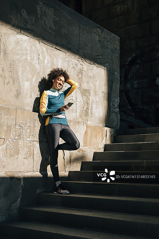 快乐的女运动员从慢跑中休息一下，听听音乐图片素材