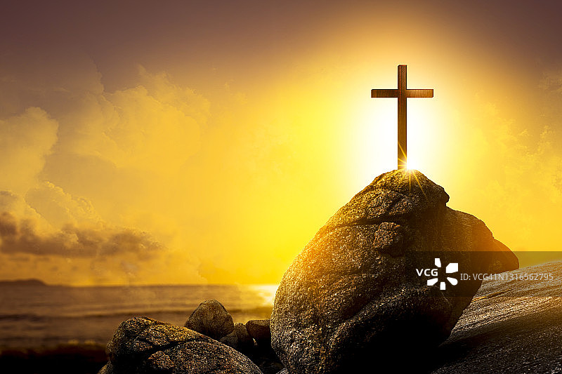 宗教基督和耶稣基督的十字架在日落，金色的光。图片素材