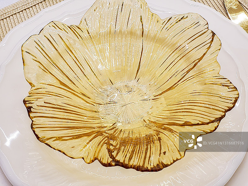金色花瓣形的盘子放在桌上图片素材