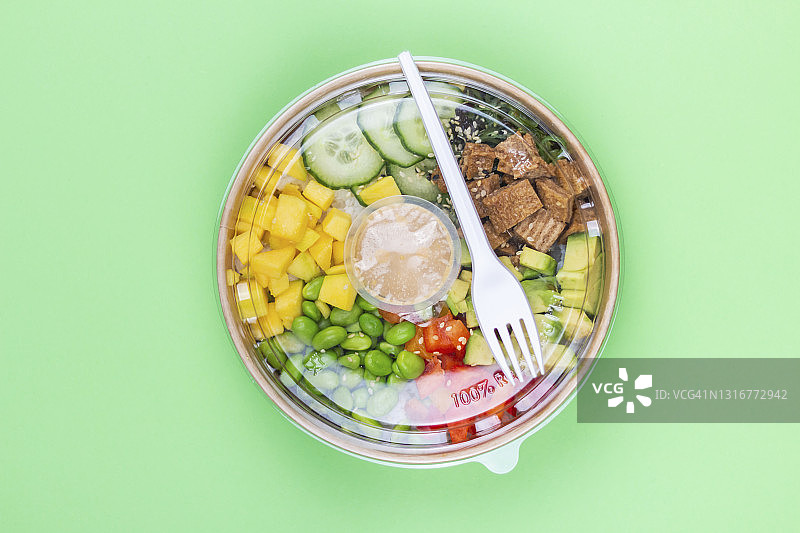 绿色背景的塑料容器中的健康午餐特写。图片素材