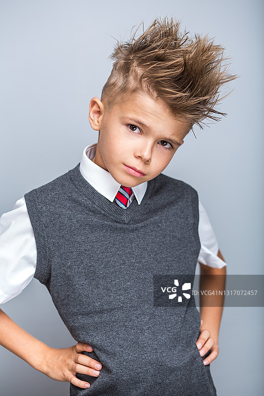 滑稽可爱的小男孩穿着优雅的校服图片素材