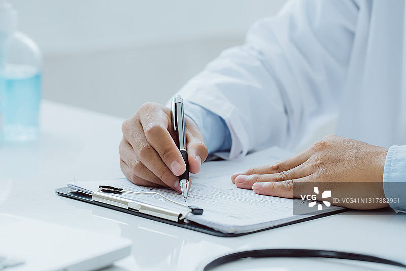 在医院工作的医生在桌子上写处方，医疗保健和医疗概念，测试结果的背景图片素材