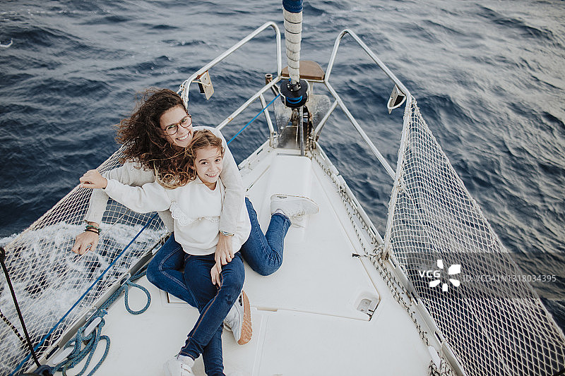 微笑的母亲和女儿在帆船上享受假期图片素材