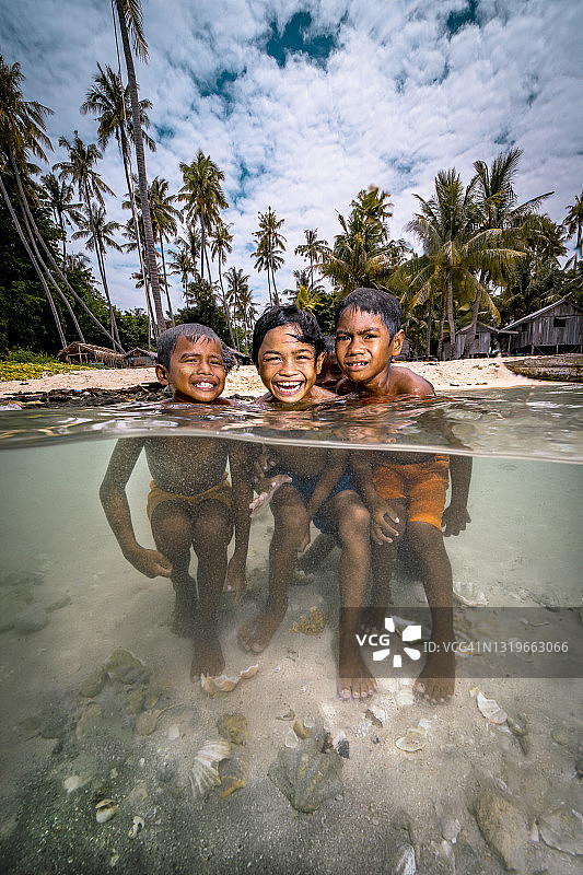 巴夭的孩子们在热带岛屿的海滩上游泳图片素材