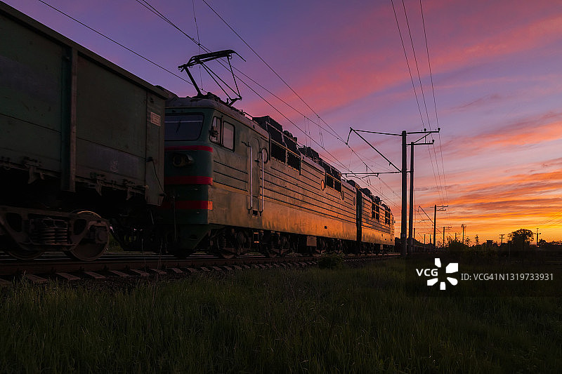 日落时火车在铁路上行驶。铁路货运与客运图片素材