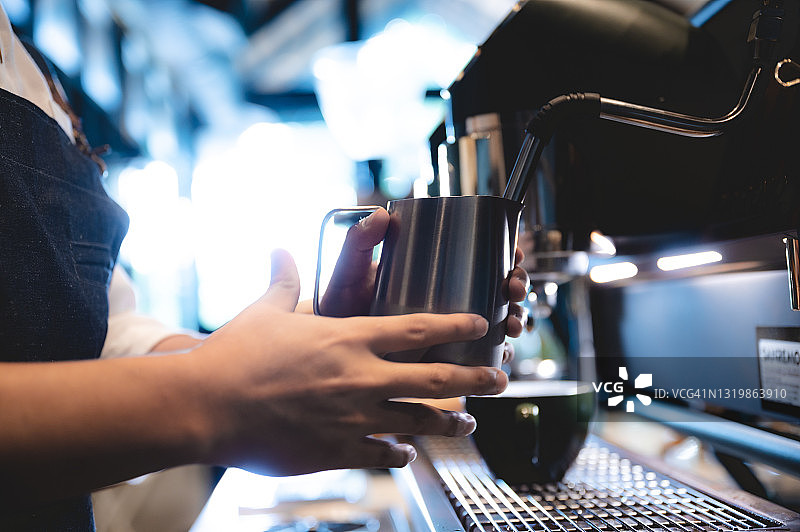 咖啡馆里的浓缩咖啡机，专业的咖啡师在商店或餐厅的吧台用一杯咖啡制作热咖啡，现代咖啡店，棕色卡布奇诺饮料机图片素材