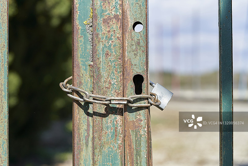 一个生锈的铁链锁在一个生锈的金属门上的特写图片素材