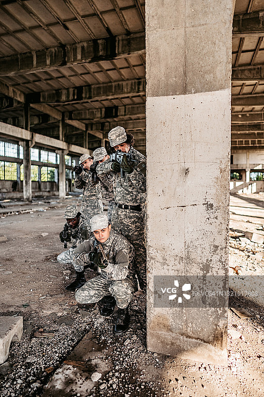 军事突击小队在废弃的大楼里掩护图片素材