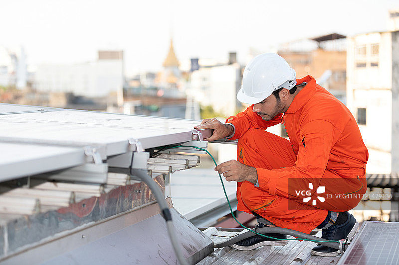 工程师或技术员检查和固定屋顶上的太阳能电池板图片素材