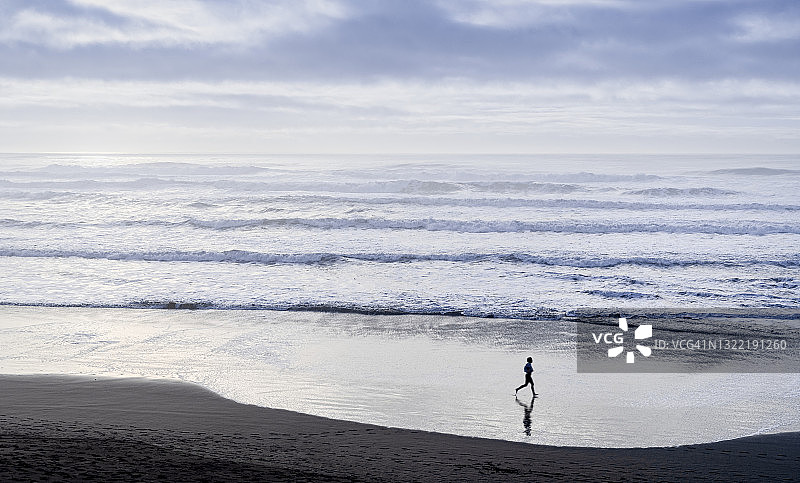 一个在海滩上慢跑的人图片素材